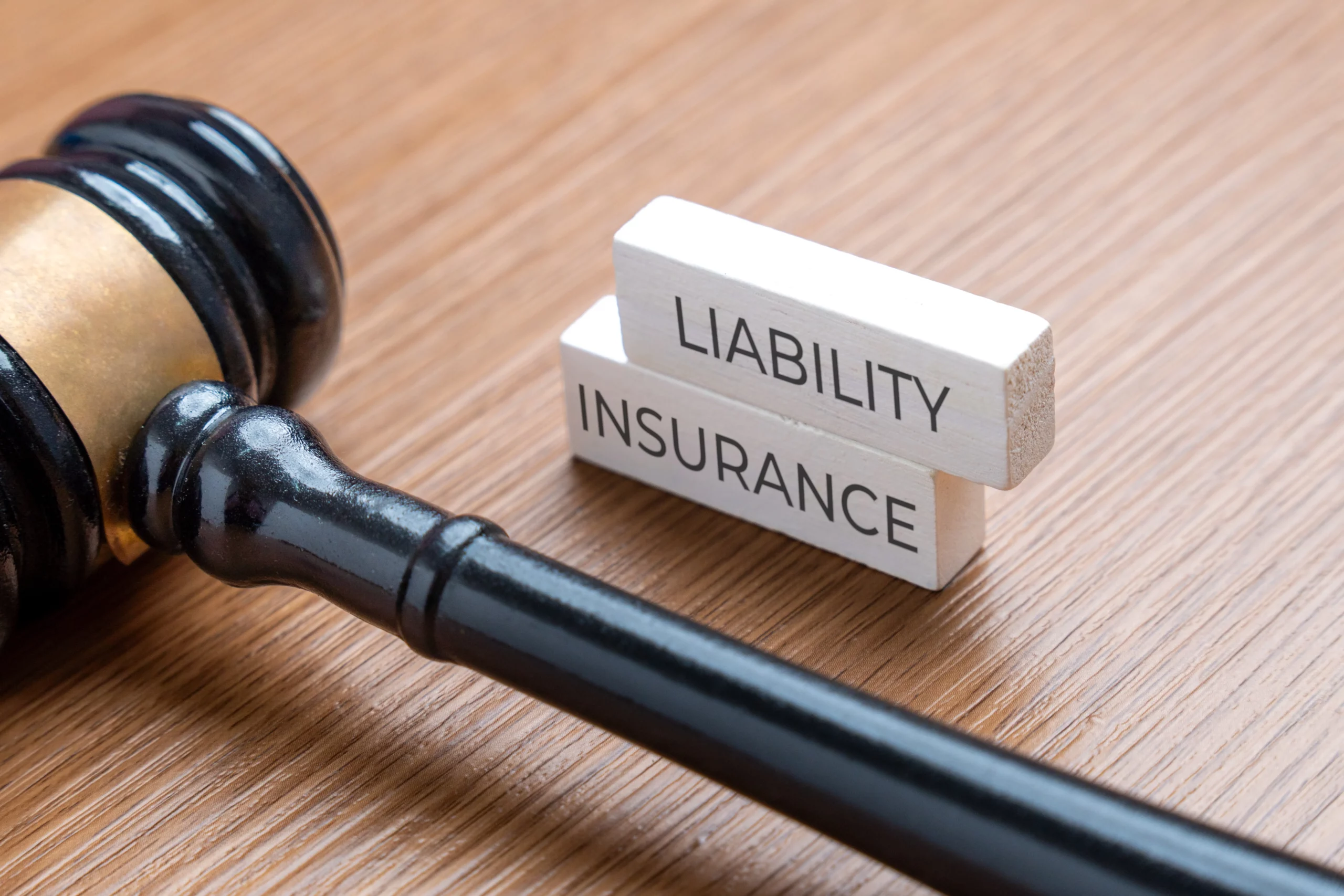 Judge’s gavel beside liability insurance blocks representing general liability insurance protection for businesses against legal and financial risks.