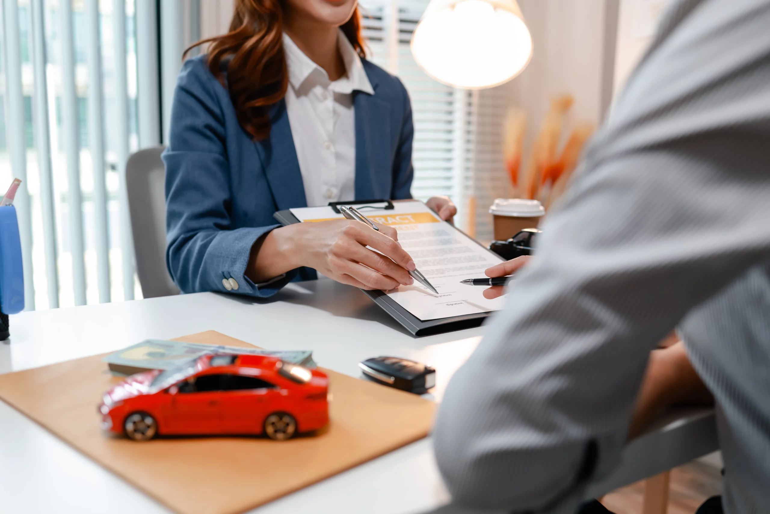 Person reviewing and signing a vehicle insurance agreement, representing rental car insurance coverage in Georgia.